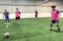 Players are playing five on five soccer on a turf soccer field 