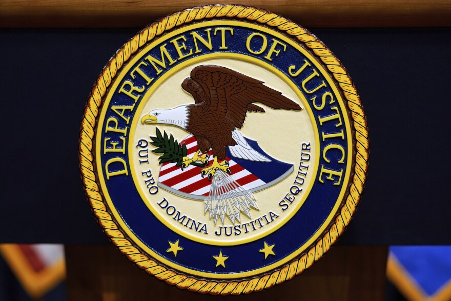 Logo of the Department of Justice with eagle and flag shield on a lectern