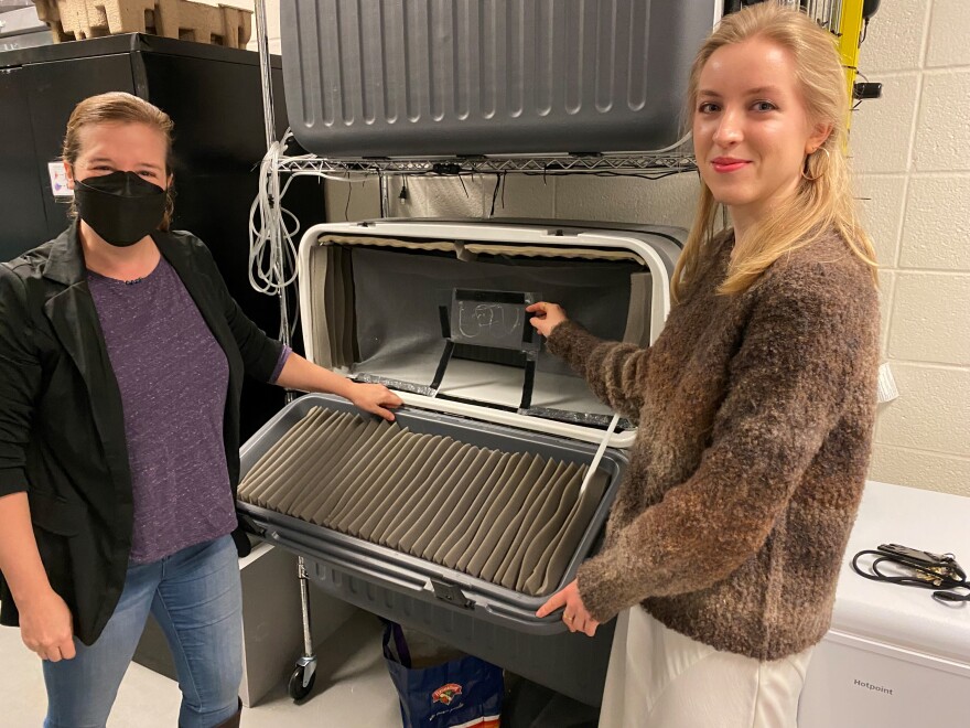 (from left) Dr. Elizabeth Hobson, assistant professor in UC's Department of Biological Sciences and UC senior Sophia Clemen stand next to a cooler retrofitted as a 'studio' to record bobwhite mating calls.