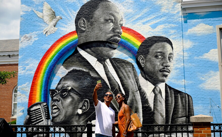 In West Hartford, the 2021 Juneteenth commemoration included the unveiling of a huge mural celebrating Black achievement. The centerpiece of the artwork features Dr. Martin Luther King Jr., flanked by prominent civil rights leaders Ella Baker and Bernard Lafayette. Above, Anthony Durant and Ebony Wilson take a selfie in front of the mural, created by local artist Corey Pane on the Noah Webster Library. The artwork is part of the CT Mural/RiseUp MLK39: Racial Equity Mural Tour project.
