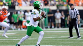 Oregon quarterback Dante Moore prepares to throw a football field.