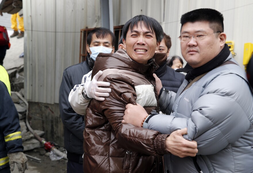 A man breaks down after seeing the body of a relative recovered from a collapsed building in Tainan, Taiwan.