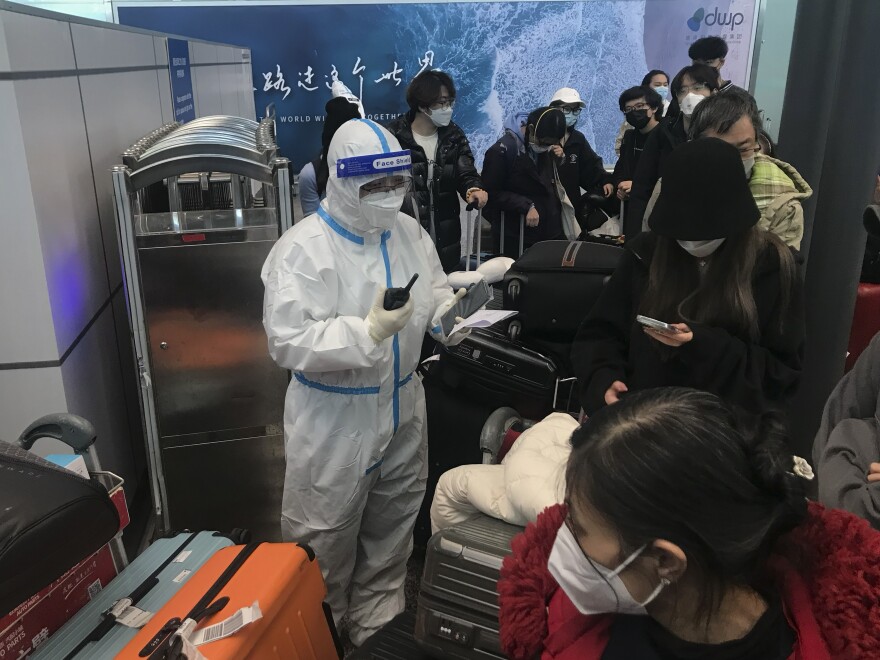 Inbound travelers wait for hours to board buses to leave for quarantine hotels and facilities from Guangzhou Baiyun Airport in southern China's Guangdong province on Dec. 25.