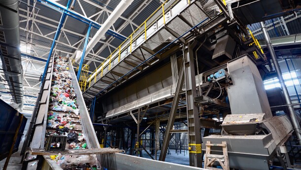 This stock image shows a recycling plant conveyor belt transports materials for sorting.