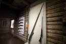 Two displays show different old rifles. One has five guns hung in a row. The other has three guns sitting on their butts.