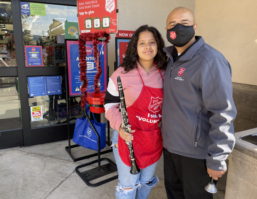 Rogelio Aguilar and his daughter, Kaylee, volunteer as bell-ringers to collect donations for the Salvation Army