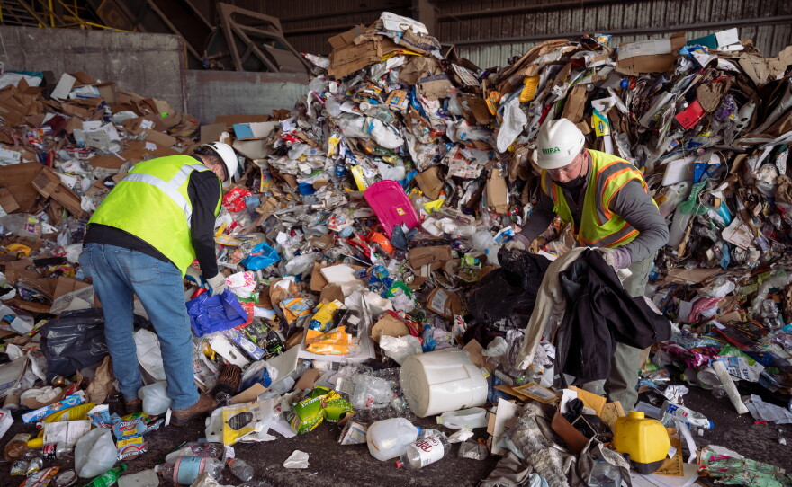 Tom Gaffey (left), MIRA’s director of recycling and enforcement, and inspector Dan Heisler pick out contaminants from a load of single-stream recycling at the MIRA intermediate processing center in Hartford. lf an incoming load of recyclables wasn't heavily contaminated with trash, it got sent to a recycling center in Berlin for sorting and later was sold or shipped out of state. Materials were sorted in the Hartford facility until the end of April 2021, when the operation was outsourced to the Murphy Road Recycling Inc. facility in Berlin.