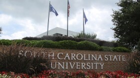 FILE - In this July 22, 2014, file photo, flags fly at the entrance to South Carolina State University in Orangeburg, S.C. A student faces charges after a shooting at South Carolina State University on Tuesday, Feb. 6, 2024 that sent the campus into lockdown for nearly one hour but did not leave any reported injuries. (AP Photo/Bruce Smith, File)