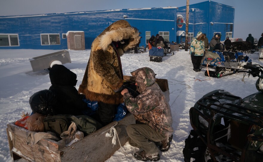 Members of Nelson Island School's basketball team prepare to travel by snow machine-pulled wooden sleds to an away game at a neighboring village.