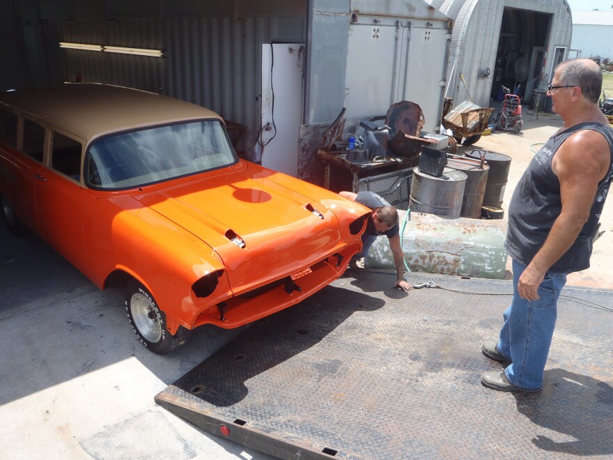 Tommy Arney, right, and "Painter Paul" Kitchens roll the freshly painted Chevy from the paint shed in July 2013