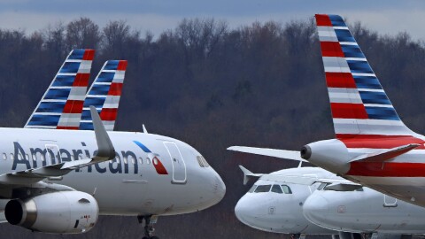 A group of American Airlines planes are parked on a tarmac.