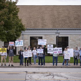 Scott County Democrats hold signs. (Chris Bentley/Here & Now)