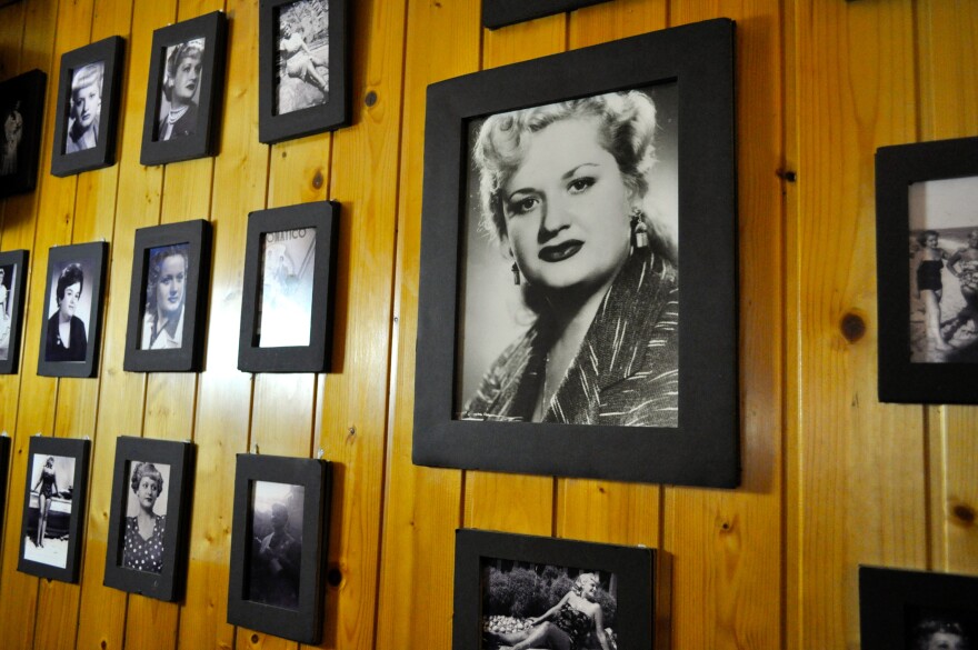 Black and white photos of the Tosca family line the wood-paneled walls of Can Tosca, a traditional Catalan restaurant in Barcelona's Grácia neighborhood.