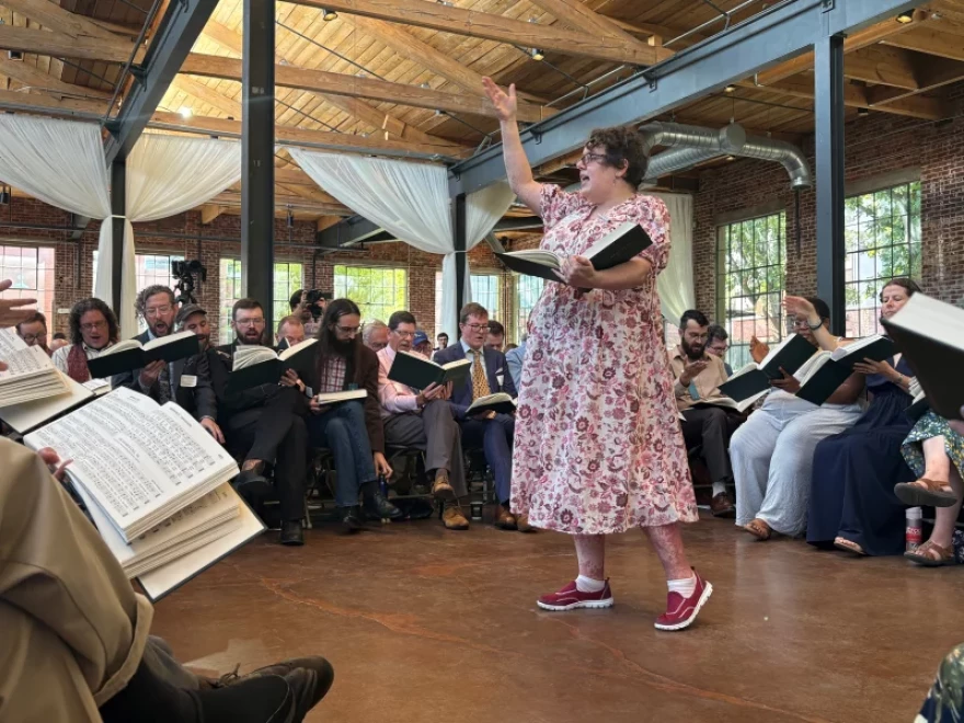 Musicologist Angharad Davis of Australia leads the song she composed for the new edition of The Sacred Harp, "Radiance," in the center of the hollow square.