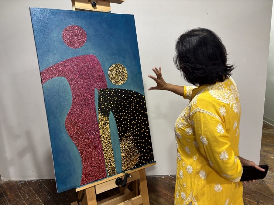 Artist Lakshmi Sriraman points to one of her paintings from the Us and Us series. She says the series has generated lots of discussion.