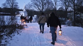 Visitors partake in a Holiday Lantern Tour outside at Hale Farm & Village