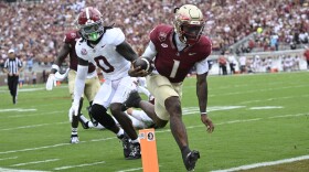 Florida State quarterback Tommy Castellanos (1) scores a 9-yard rushing touchdown past Alabama linebacker Deontae Lawson (0) during the first half of an NCAA college football game, Saturday, Aug. 30, 2025, in Tallahassee, Fla. (AP Photo/Phelan M. Ebenhack)