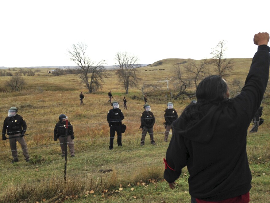 A Dakota Access pipeline protester defies law enforcement officers who are trying to force them from a camp on private land in the path of pipeline construction, Thursday, Oct. 27, 2016 near Cannon Ball, N.D.