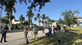 Protesters line Okeechobee Boulevard in West Palm Beach on Friday, May 1, 2026, as President Trump is slated to speak at the Kravis Center. Protesters interviewed by WLRN cite the war in Iran and the Trump administration's immigration agenda as motivators for attending.