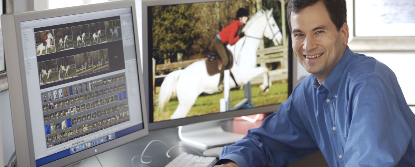 David Pogue, author of "Apple: The First 50 Years," reviews images of a person riding on horseback at his desktop computer.