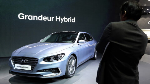 A man takes a photo of Hyundai Motor's Grandeur Hybrid vehicle during a media preview of the 2017 Seoul Motor Show in Goyang, South Korea, Thursday, March 30, 2017.