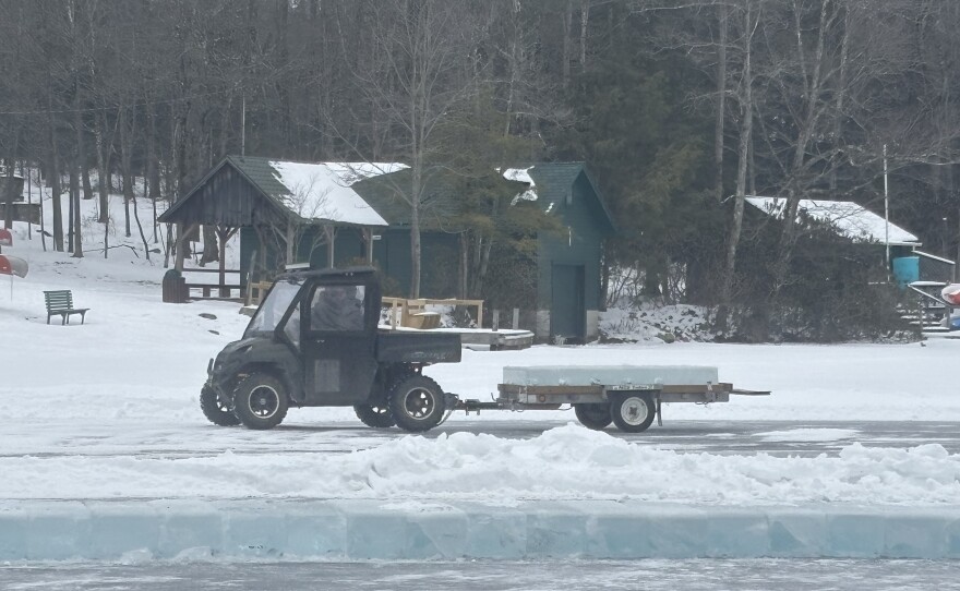 On Eagles Mere Lake, an UTV carries blocks of ice to build the toboggan slide.