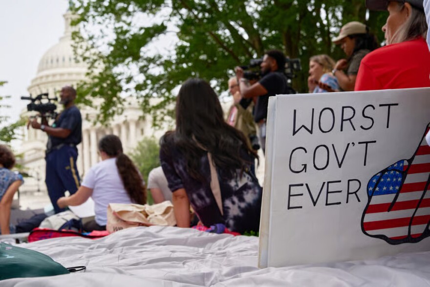 A sign saying "worst government ever" is seen by the Capitol during a rally with fired federal workers about the looming government shut down, Tuesday, Sept. 30, 2025, on Capitol Hill in Washington.
