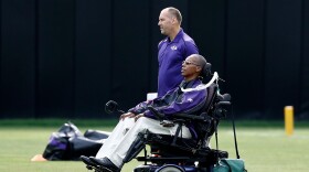 FILE - Baltimore Ravens senior advisor to player engagement O.J. Brigance, bottom, watches an NFL football training camp practice in Owings Mills, Md., Aug. 8, 2017. (AP Photo/Patrick Semansky, File)