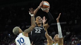 Las Vegas Aces center A'ja Wilson (22) shoots over Minnesota Lynx guard Courtney Williams (10) and forward Napheesa Collier (24) during the first half of a WNBA basketball game Wednesday, Aug. 21, 2024, in Las Vegas. (AP Photo/John Locher)