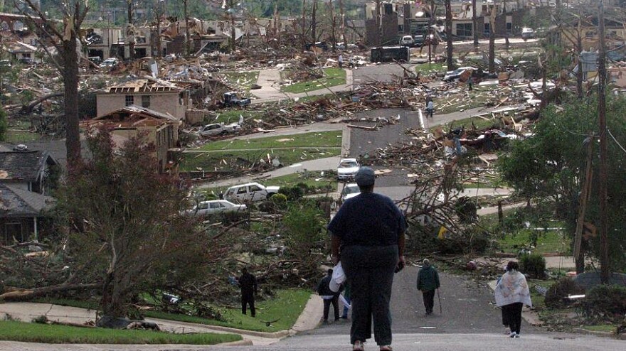 Neighbors look over the devastated Smithfield Estates neighborhood in North Birmingham, Ala.