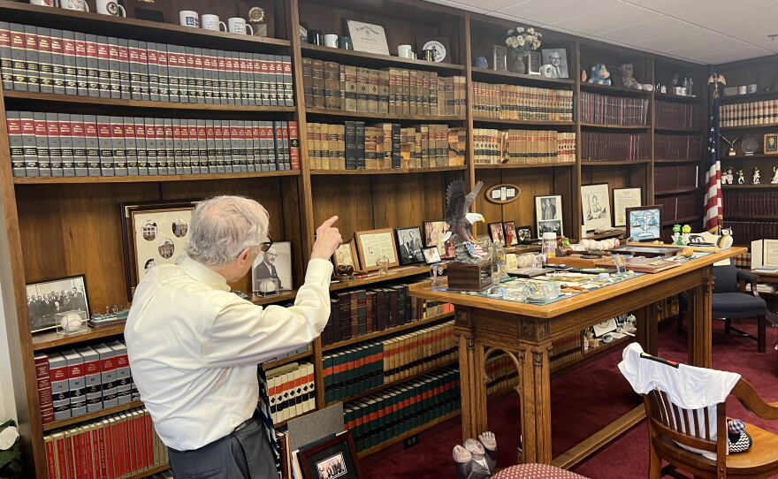 U.S. District Court Judge Walter Rice points to books on the massive shelves in his Dayton Chambers