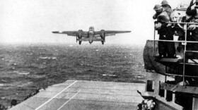 U.S. Navy crewmen watch a B-25 bomber take off from the USS Hornet for the Doolittle Raid on Tokyo on April 18, 1942.