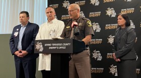 Grand Traverse County Sheriff Michael Shea briefs reporters on Sunday afternoon, the day after a stabbing attack at the Walmart Supercenter in Garfield Township. With him, from left to right, are Joe Hurshe, president and CEO of Munson Medical Center; Dr. Tom Schermerhorn, chief medical officer at Munson; and Grand Traverse County Prosecutor Noelle Moeggenberg. (Photo: Claire Keenan-Kurgan/IPR News)
