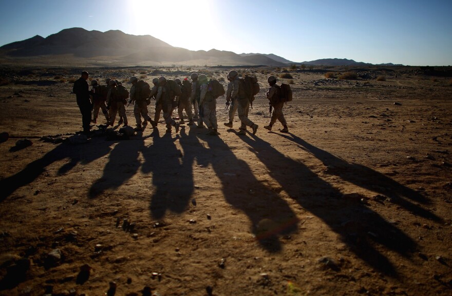 Male and female Marines hike up to a range at Twentynine Palms, a training base in the Mojave Desert, to participate in a live-fire exercise.