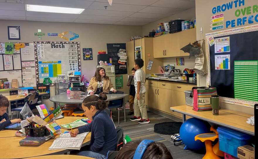 Addie Santillan smiles up at students as they approach her during class.