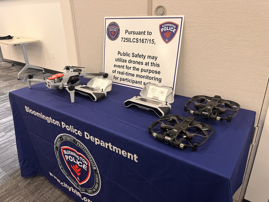 Three drones and two controllers sit on a table