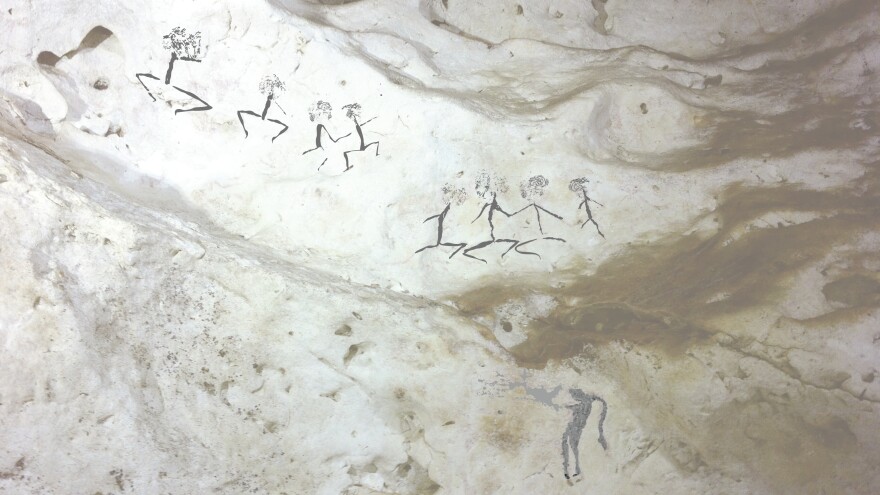 Paintings of human figures on Borneo could be up to 20,000 years old. Researchers say they found paintings of people wearing headdresses and carrying spears.