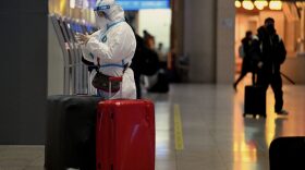 A passenger wearing personal protective equipment to halt the spread of Covid-19 arrives at a train station in Beijing.