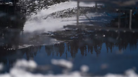Reflected in a pool of melting ice, dirt and grass show through the low snowpack at Mt. Hood Meadows on the resort’s second-to-last weekend in Mt. Hood, Ore., on April 4, 2026.