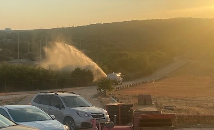 Water truck wets down brush near the firing area before the show