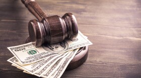 Gavel and some dollars banknotes on wooden table.Auction bidding, judicial system corruption concept.Toned