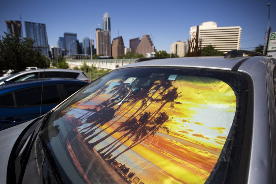 A sun shade depicting a sunset on a car parked at Vic Mathias Shores, with the Austin city skyline behind