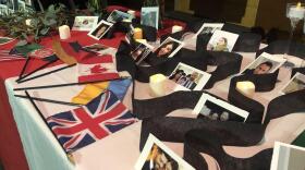 Photos of the plane crash victims and their national flags on display during Monday's vigil.