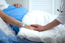 Doctor holding pregnant woman hand with catheter, birth defects prevention