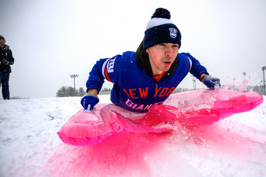 Riding an inflatable pool float, UConn student Nater Herman heads down a hill covered in fresh snowfall while sledding with Jackson Gearney (left), January 07, 2024. Both students work as student managers for the UConn Men’s basketball team and said they wanted to get some sledding in before the team practiced later in the day.