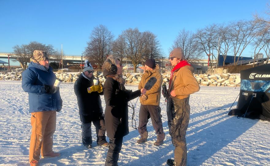 Minneapolis resident Peter Tanis (far left) traveled with two friends to experience ice fishing at Lakeshore State Park. Here, they talk with WUWM reporter Susan Bence.