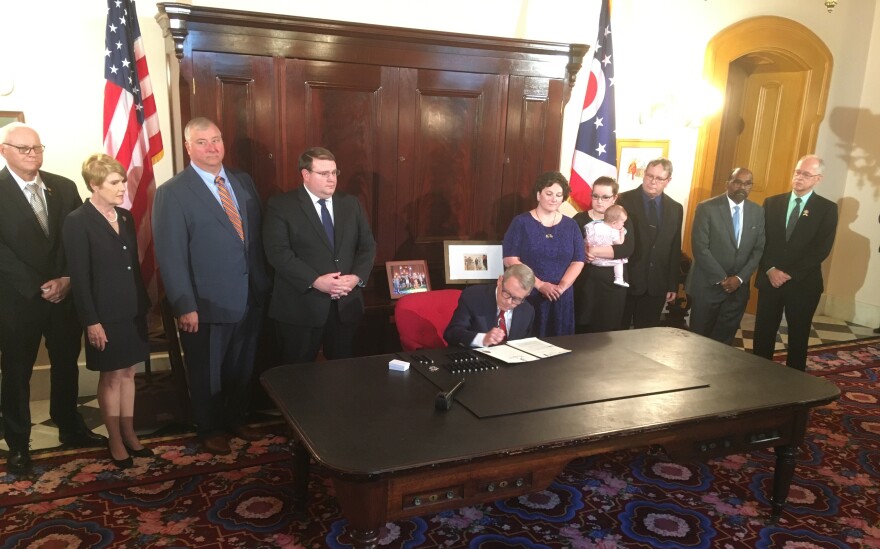 People watching DeWine sign bill.