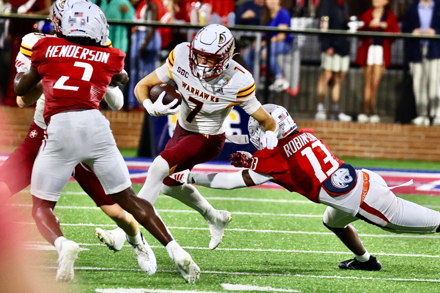 Picture of ULM receiver breaking an arm tackle from a Jaguar defender.
