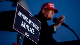 Republican presidential candidate, former President Donald Trump stands next to a podium placed next to him to challenge President Biden to a debate as he speaks at a rally outside Schnecksville Fire Hall in Schnecksville, Pennsylvania.