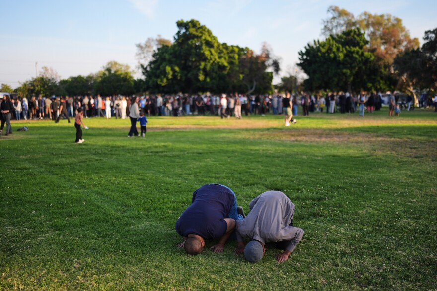 Two people pray during a vigil, the day after a shooting, outside of the Islamic Center of San Diego, Tuesday, May 19, , in San Diego. (AP Photo/Jae C. Hong)